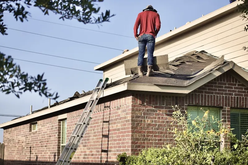 Professional roofer working on a residential roof in Southwest Warren